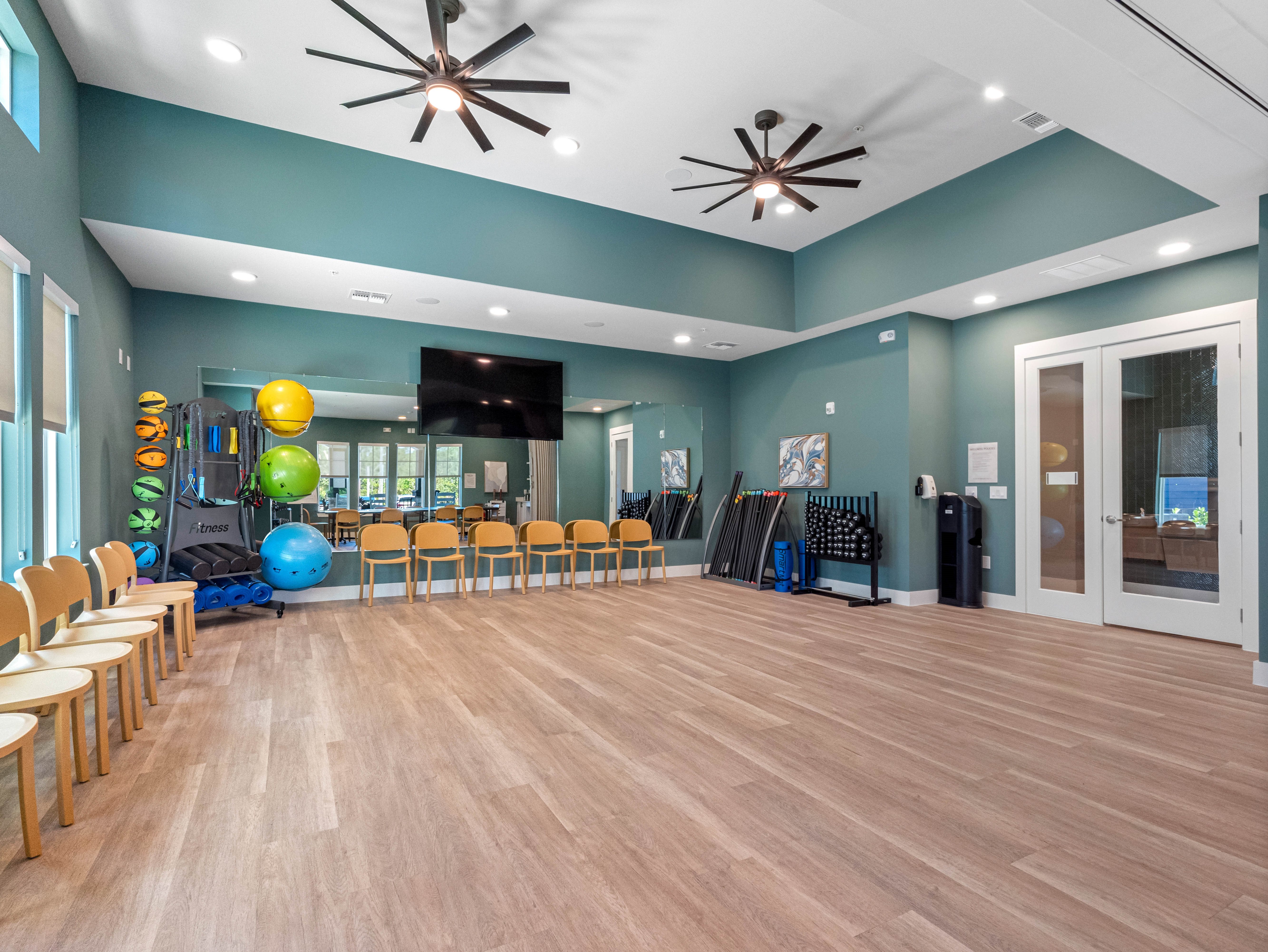 A room with wooden floors and a ceiling fan.